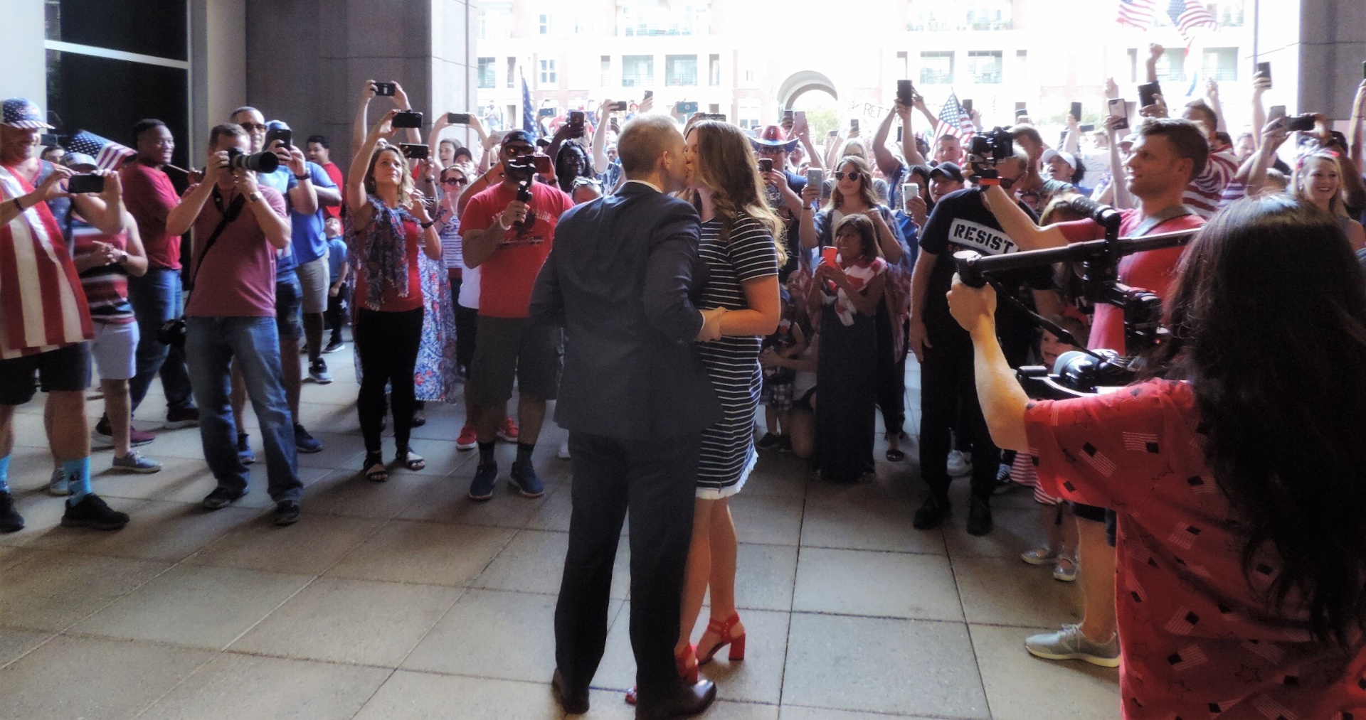 Zac and Jill Newell sharing a kiss surrounded by a crowd